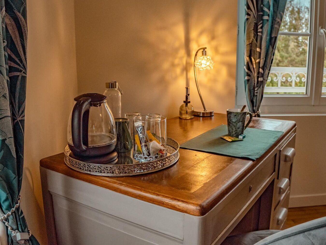 Eine Küchenarbeitsplatte mit Kaffeemaschine, Glasbehältern und einer Lampe.