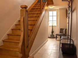 Una escalera de madera que lleva a una plataforma con una silla y una pequeña mesa.