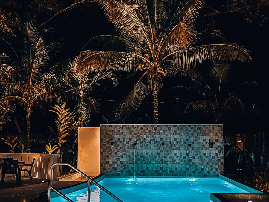 Una piscina al aire libre, sombrillas, sillones reclinables de piscina