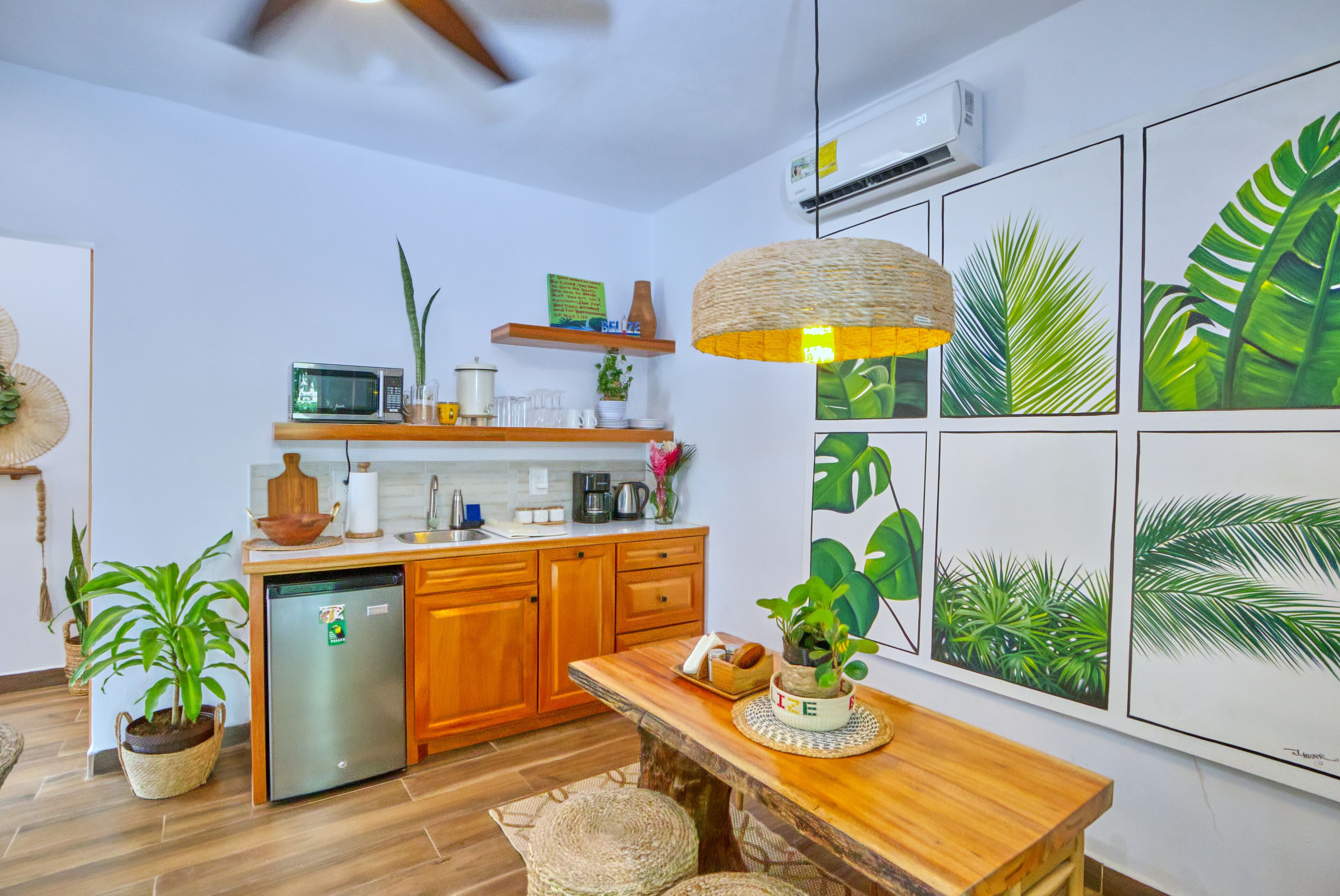 A modern kitchen with wooden cabinets, a built-in microwave, and a central island with a hanging light fixture.