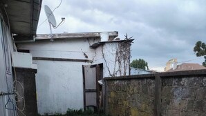 Un pati amb una antena parabòlica, una paret de formigó i una petita zona de gespa.