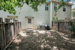 A backyard with a wooden fence, a door, and an air conditioning unit. - SP3  Newly Reno Home 30% OFF! Mins to Medical Center (San Antonio)