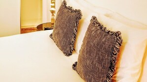 Un dormitorio con una cama, dos almohadas y tres espejos adosados a la pared.