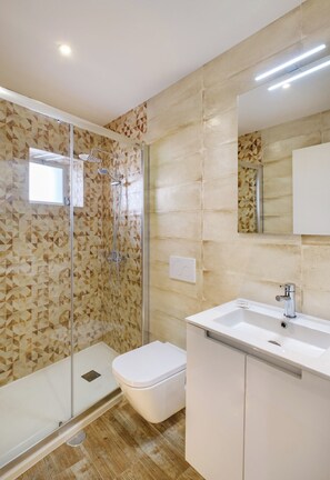 A bathroom with a shower, toilet, and sink.