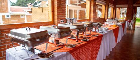 Un buffet avec plusieurs points de service, chacun équipé d’un grand récipient en métal et d’ustensiles de service.