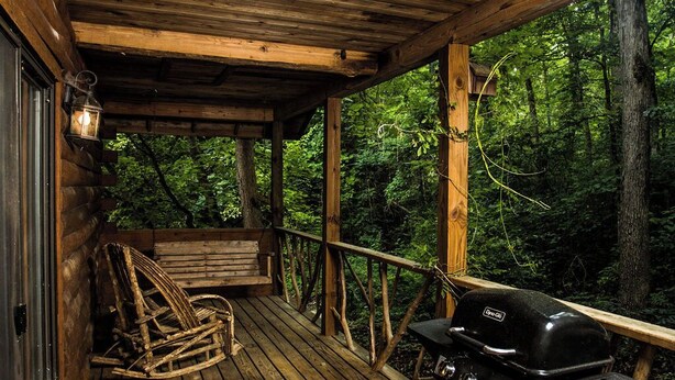 A wooden deck with a grill and propane tank, a bench, and a lantern. - Bear Hollow near the Buffalo River  (Jasper)
