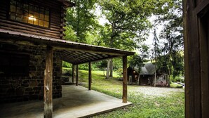A rustic cabin with a covered porch and a stone wall. - Bear Hollow near the Buffalo River  (Jasper)