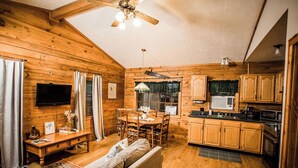 A cozy cabin interior with a wooden interior, a dining area, a sofa, and a kitchen. - Bear Hollow near the Buffalo River  (Jasper)