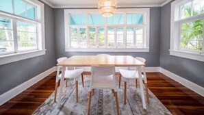 Una sala da pranzo con un tavolo grande e sedie, ampie finestre e un tappeto decorato.