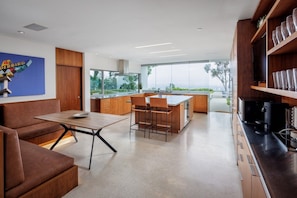 Een moderne keuken met een centraal eiland, houten keukenkastjes en uitzicht op de omgeving.
