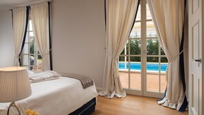 Una habitación de hotel con una cama, una lámpara y vistas a una piscina.