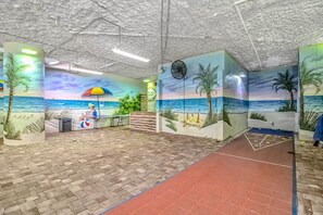 A beach-themed interior with murals, a reception desk, and a red carpeted area. - Oceanfront Studio • Indoor Waterparks • Dunes Village Resort (Myrtle Beach)