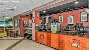 A restaurant interior with a counter, chairs, and framed pictures on the wall. - Oceanfront Studio • Indoor Waterparks • Dunes Village Resort (Myrtle Beach)