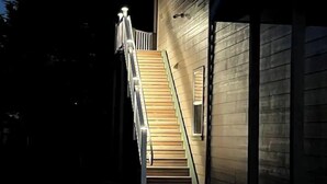 A staircase leading to a wooden door, with a railing and lights on the side. - OCTOPUS SUITE, fire pit, BBQ, wildlife viewing platform, shared oceanfront deck. (Brookings)