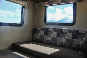 Cozy retreat with a mountain view, featuring a compact bed and window.