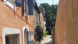 A narrow cobblestone street flanked by buildings with stone walls and wooden doors. - Pleasant house 4/6 persons free parking (Sauvian)