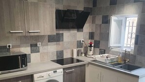 A compact kitchen with a microwave, washing machine, and a sink. - Pleasant house 4/6 persons free parking (Sauvian)