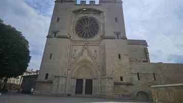 A historic stone building with a large circular window and two symmetrical towers.