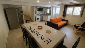 A modern kitchen with a dining area, a sofa, and a chair. - Pleasant house 4/6 persons free parking (Sauvian)