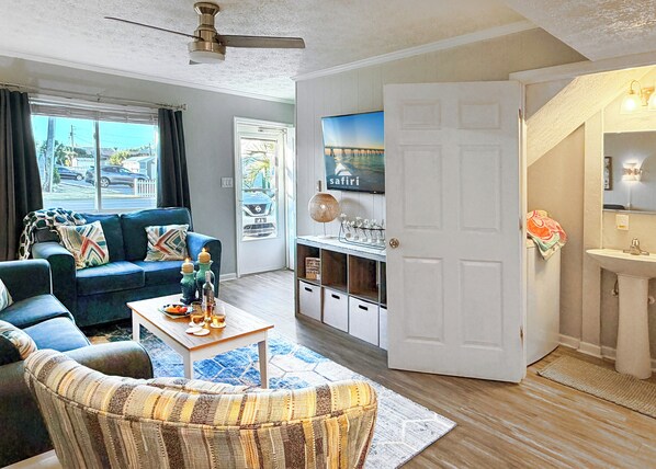 A living room with a sofa, coffee table, and a TV mounted on the wall.