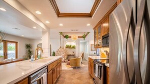 A modern kitchen with wooden cabinets, stainless steel appliances, and a central island. - Luxury Joshua Tree Retreat w/ Hot Tub, BBQ and Games (Joshua Tree)