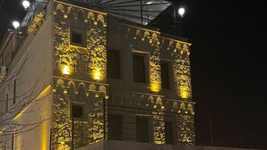 A building with illuminated architectural details and a covered entrance.