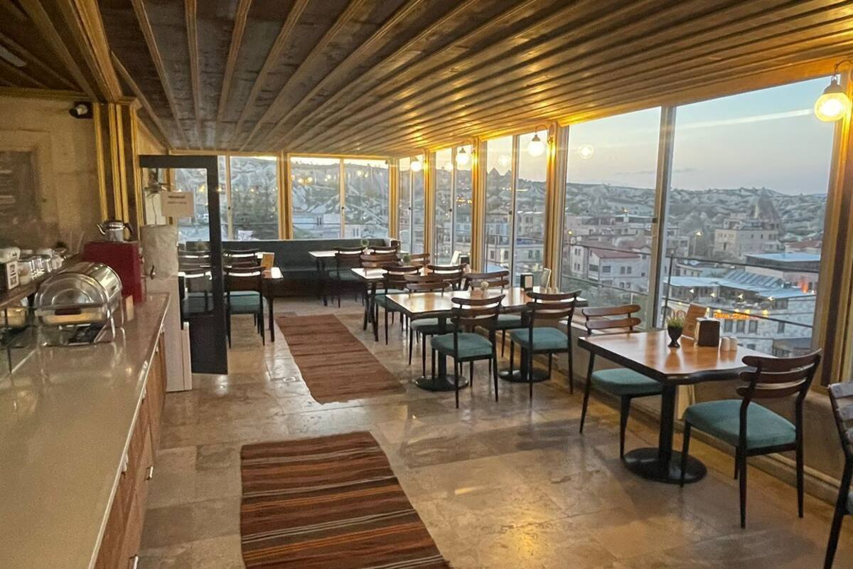Un restaurante con techos altos y amplias ventanas que ofrecen vistas a la ciudad.