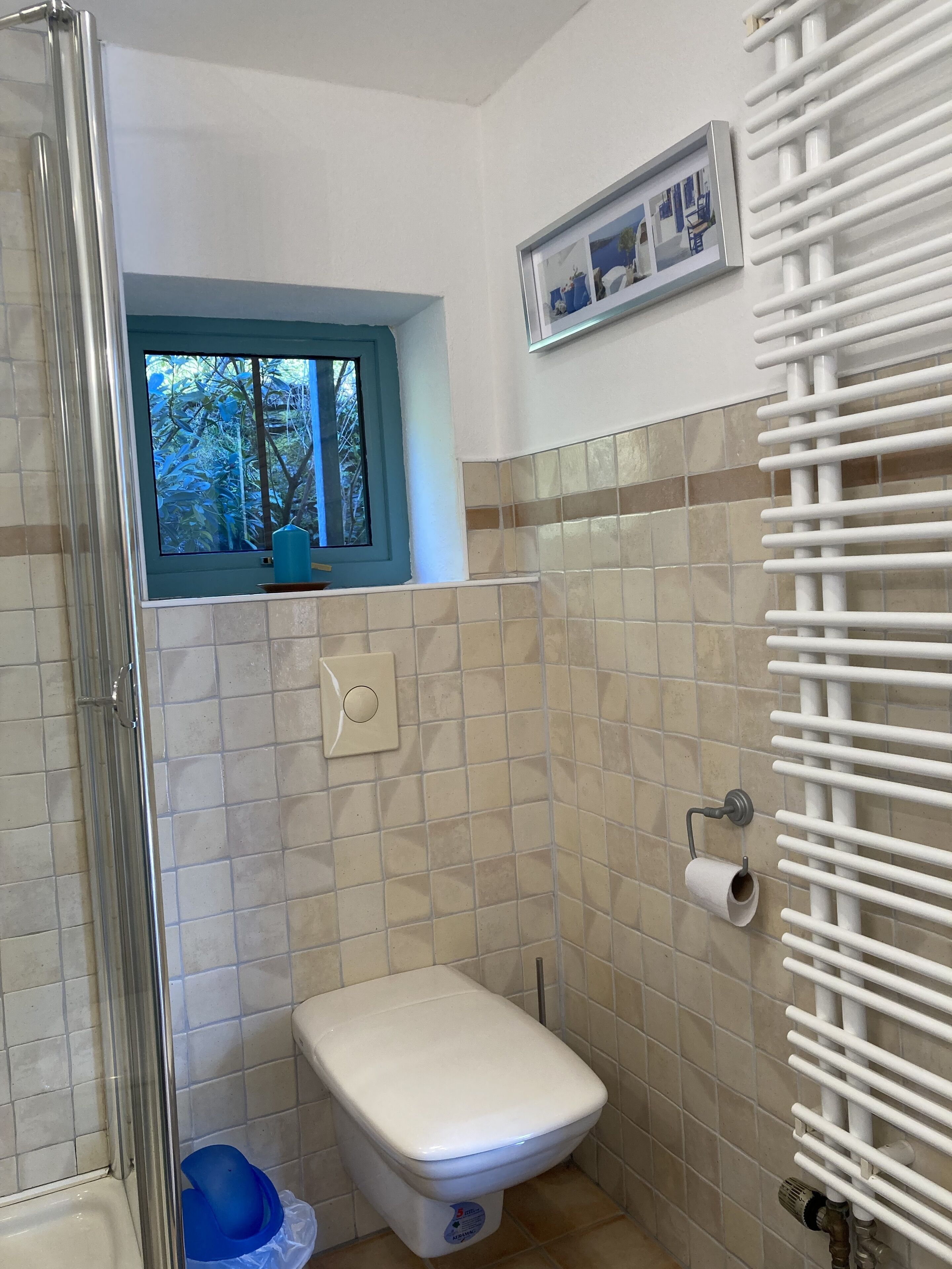 Ein kleines Badezimmer mit Toilette, Dusche und Fenster.