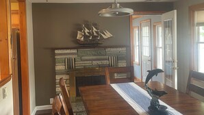 A dining room with a long wooden table, chairs, and a decorative ship model on the wall. - Cape May short walk to the Bay Dogs Welcome!  (Lower Township)