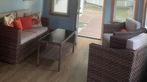 A room with a ceiling fan, two windows, a sofa, a coffee table, and wicker furniture. - Cape May short walk to the Bay Dogs Welcome!  (Lower Township)