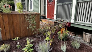 A garden with various plants and a wooden fence. - The Garrison House Inn (Annapolis Royal)