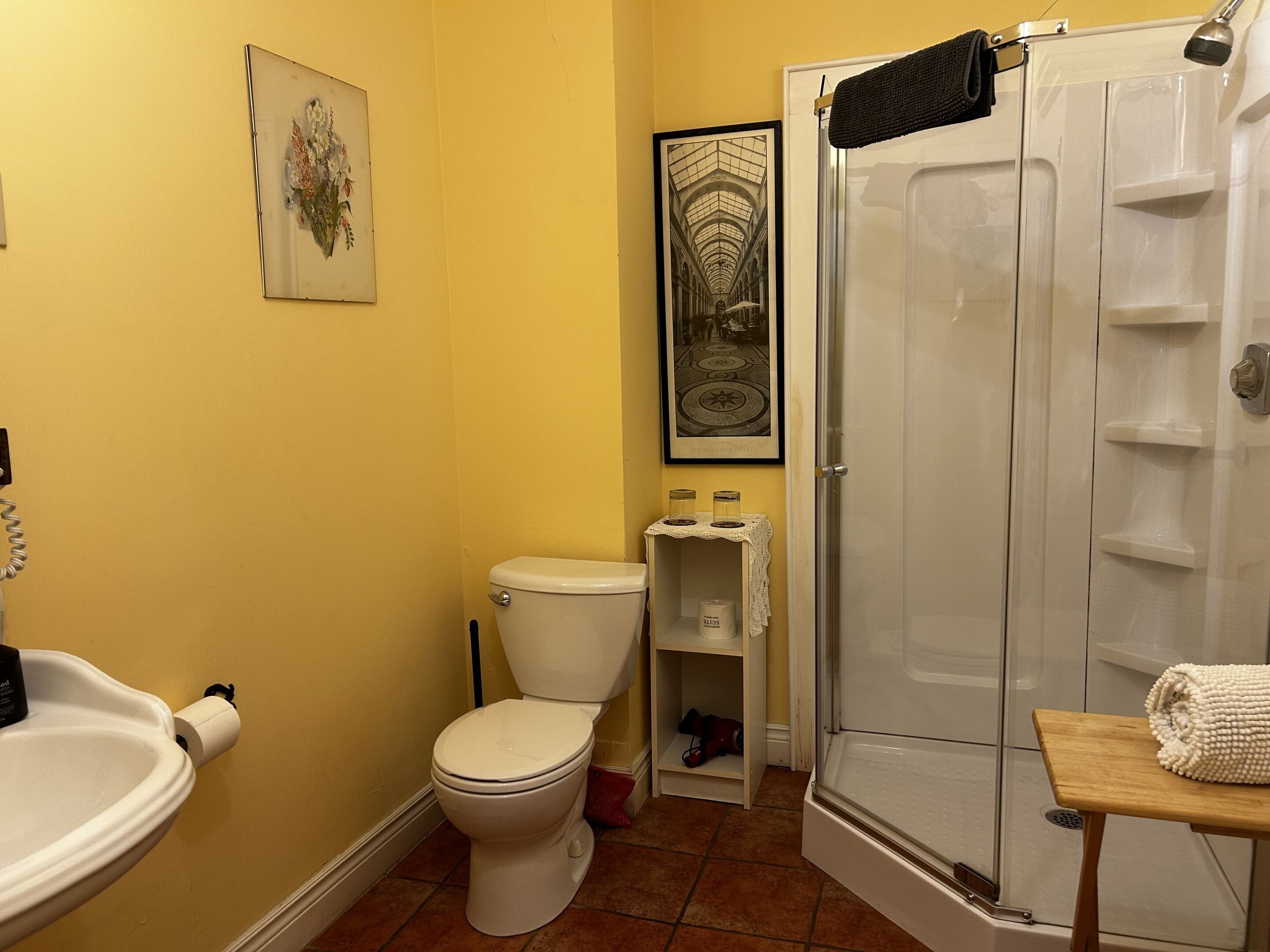 A bathroom with a toilet, sink, and shower.