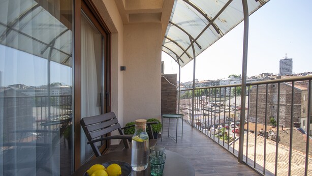 A balcony with a table, two chairs, a bottle of water, and a bowl of lemons. - Cozy penthouse, terrace, artisan touch perfect espresso & perks (Belgrade)