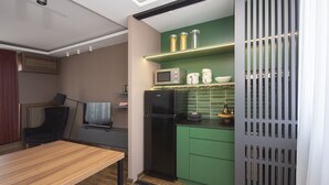 A compact kitchen with a microwave, refrigerator, and green cabinets. - Cozy penthouse, terrace, artisan touch perfect espresso & perks (Belgrade)