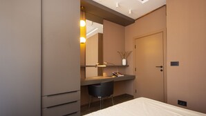 A modern hotel room with a bed, a desk with a chair, a mirror, and a wardrobe. - Cozy penthouse, terrace, artisan touch perfect espresso & perks (Belgrade)