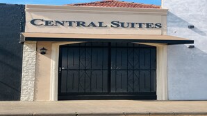 A building with a sign reading 'CENTRAL SUITES' above a black gate.