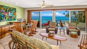A spacious living area with a balcony overlooking the ocean, furnished with wicker chairs and a dining table. - Oceanfront Hale Hui Kai 313 Large Lanai, AC, Incredible Views on Keawakapu Beach (Kihei)