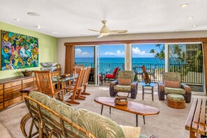 A spacious living area with a balcony overlooking the ocean, furnished with wicker chairs and a dining table. - Oceanfront Hale Hui Kai 313 Large Lanai, AC, Incredible Views on Keawakapu Beach (Kihei)