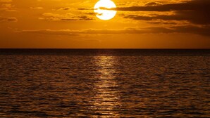 A sunset over a calm body of water with a visible horizon line. - Oceanfront Hale Hui Kai 313 Large Lanai, AC, Incredible Views on Keawakapu Beach (Kihei)