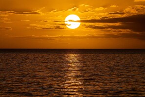 A sunset over a calm body of water with a visible horizon line. - Oceanfront Hale Hui Kai 313 Large Lanai, AC, Incredible Views on Keawakapu Beach (Kihei)