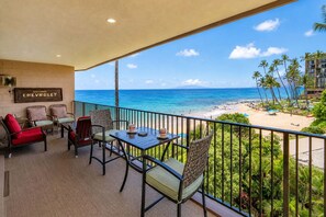 A balcony with a view of the beach and ocean, furnished with chairs and a table. - Oceanfront Hale Hui Kai 313 Large Lanai, AC, Incredible Views on Keawakapu Beach (Kihei)