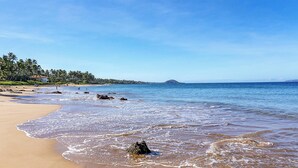 A beach with clear water, a sandy shore, and a distant island. - Oceanfront Hale Hui Kai 313 Large Lanai, AC, Incredible Views on Keawakapu Beach (Kihei)