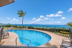 A swimming pool with a view of the ocean and a palm tree. - Oceanfront Hale Hui Kai 313 Large Lanai, AC, Incredible Views on Keawakapu Beach (Kihei)