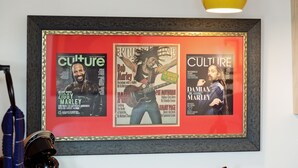 A framed collage of magazine covers on a wall.