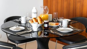 A breakfast table set with croissants, a bottle of Matina juice, a jug of orange juice, and various breakfast items. - Exquisite modern apartment [112] (Lagos)