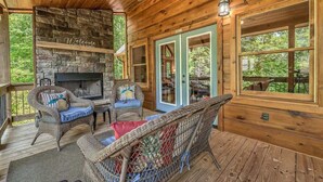 A wooden deck with wicker furniture, a stone fireplace, and a view of the outdoors. - Take a Paws - close to downtown, fenced yard, pets (Blue Ridge)