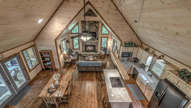 A spacious loft-style interior with a high ceiling, a fireplace, a dining area, and a kitchen. - Take a Paws - close to downtown, fenced yard, pets (Blue Ridge)