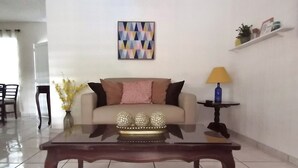Ein Wohnzimmer mit einer Couch, einem Couchtisch, einer Lampe und einem Wandbild.