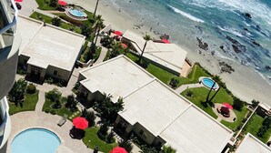 A resort with multiple swimming pools, a beach, and ocean views.