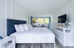 Et moderne hotelværelse med en stor seng, et skrivebord og et fjernsyn.
